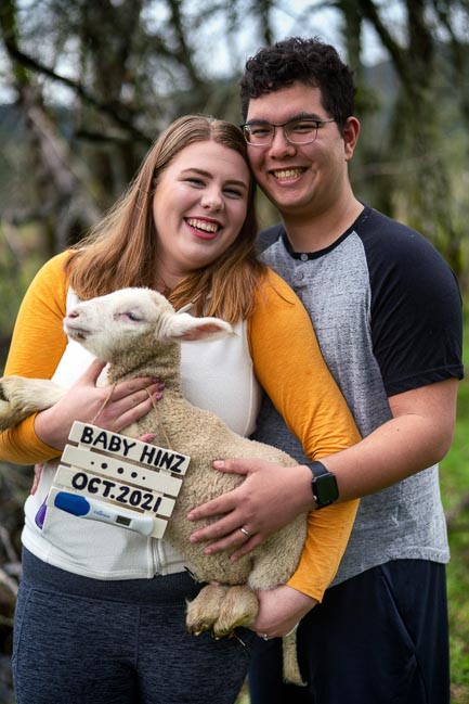 A couple holding a lamb at a fair.