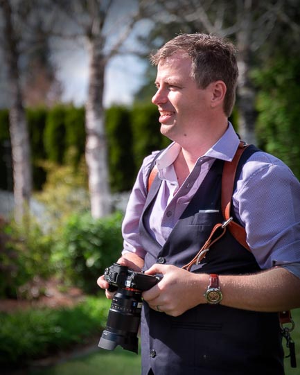 Scott Kemp holding a camera outdoors.