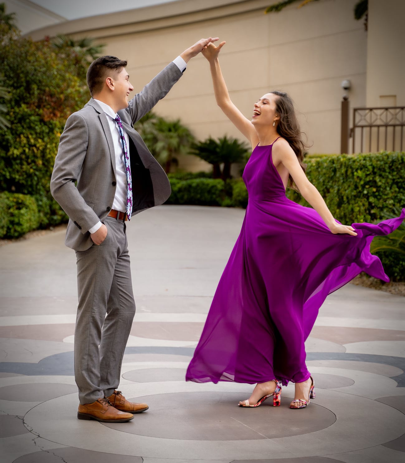 A couple dances in a courtyard, her purple dress swirling.