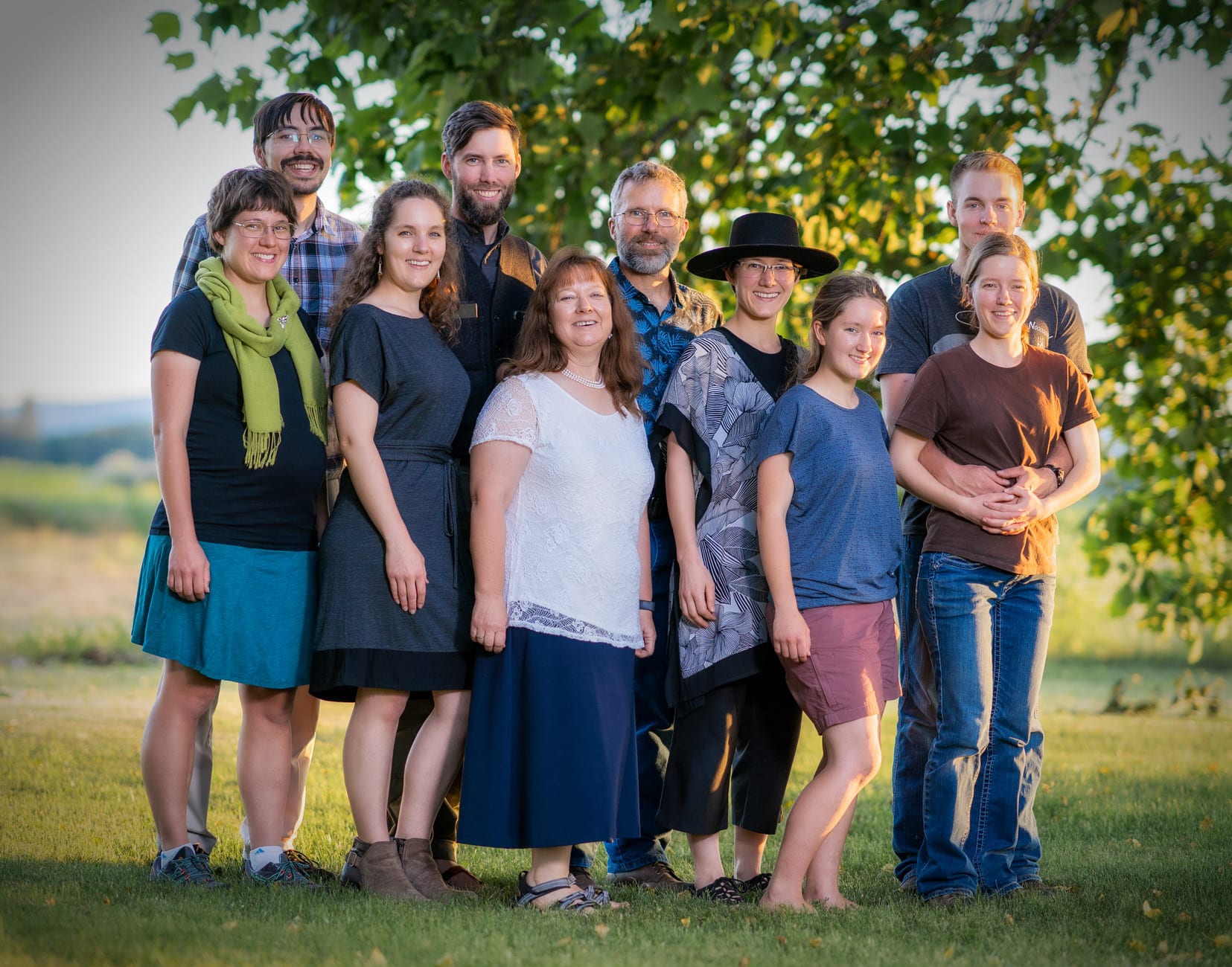 Three generations of a family stand together in a field.