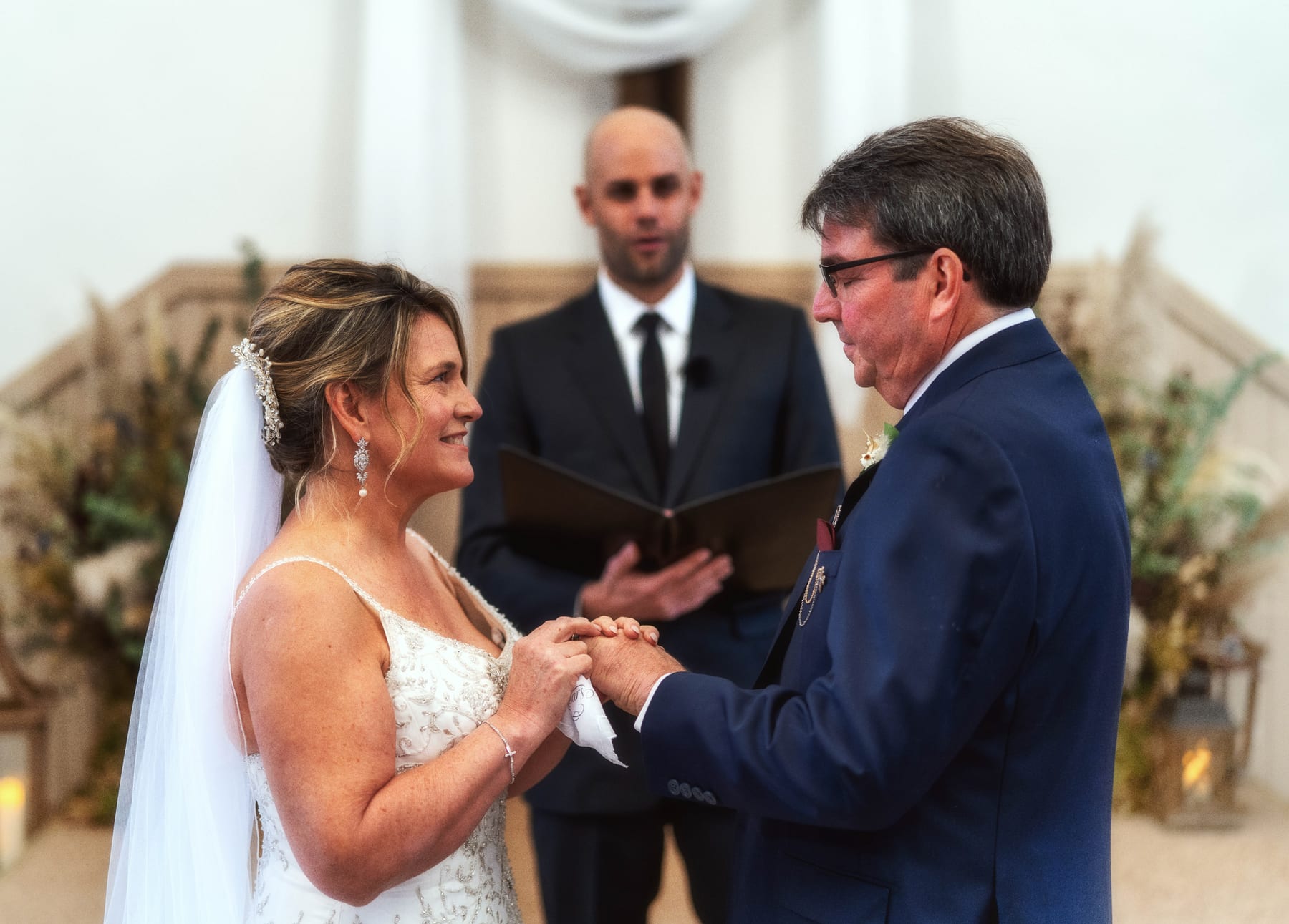 A couple holds hands and exchanges vows inside a small chapel.