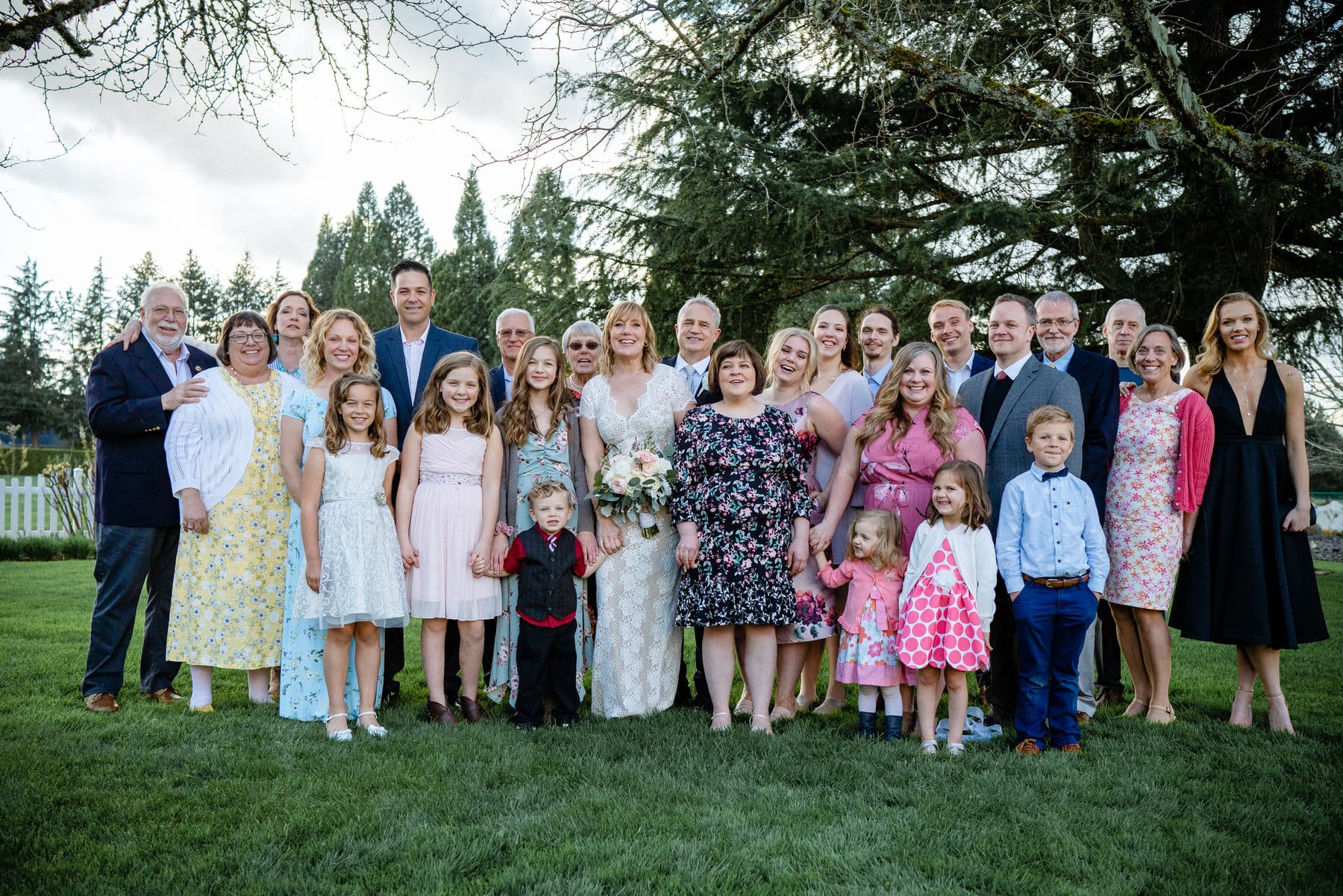 An extended family gathers around a couple on their wedding day.