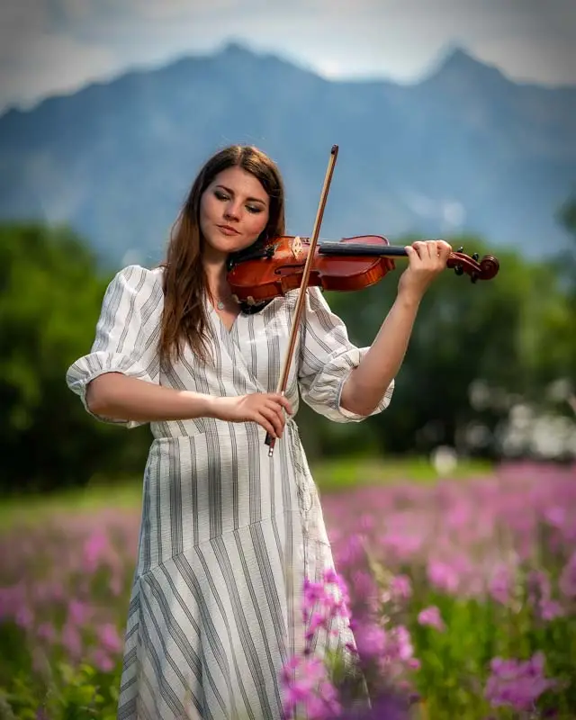 Senior playing violin outdoors.