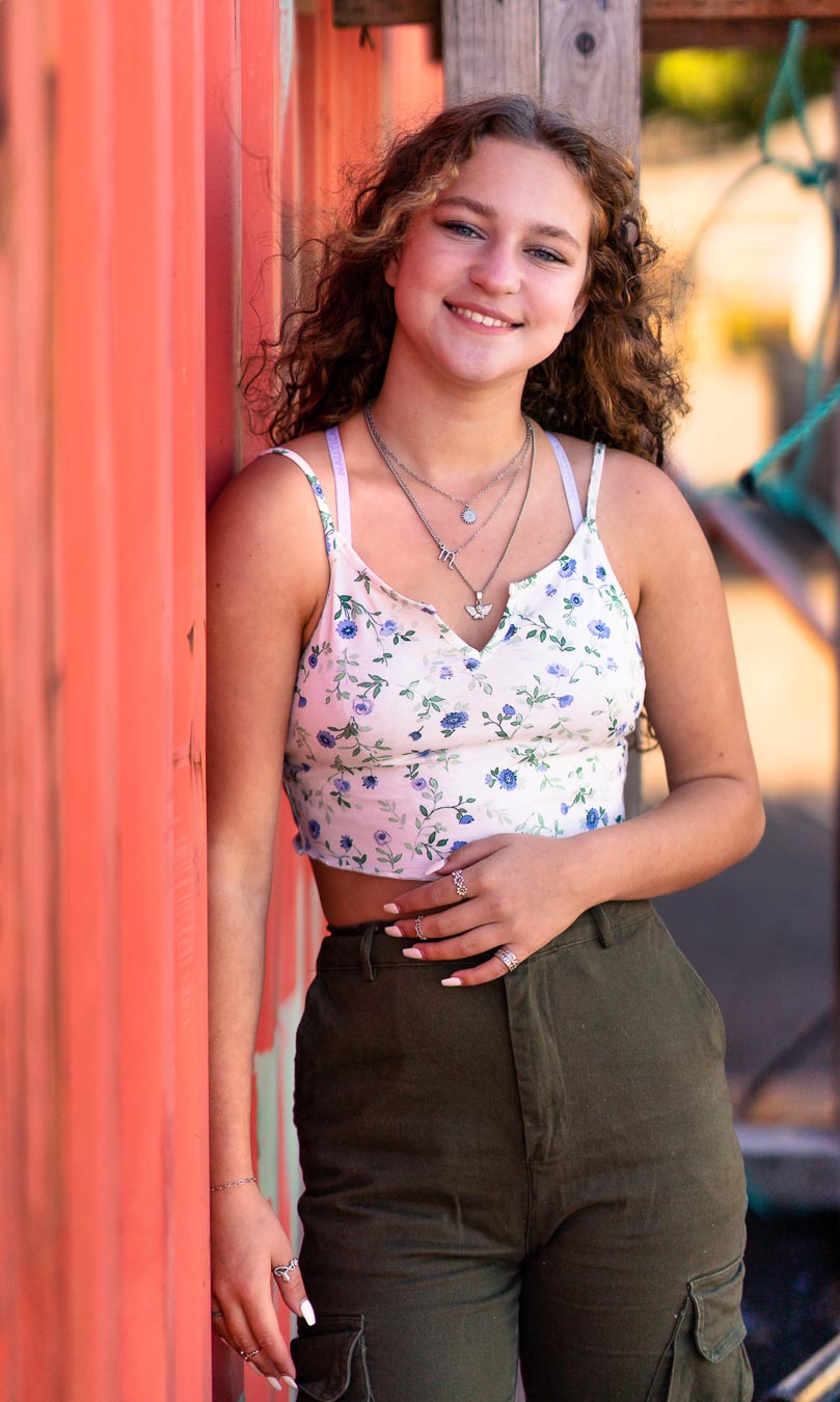 Senior portrait wall art beside a red door.