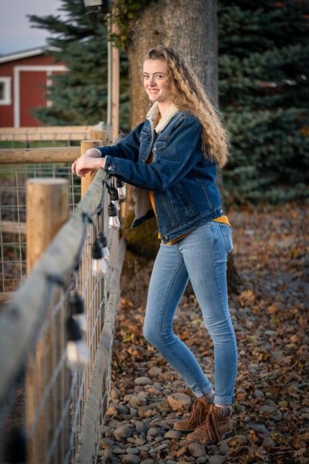 Senior portrait beside a fence.