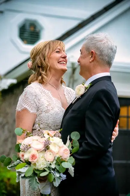 A newlywed couple laughing together.