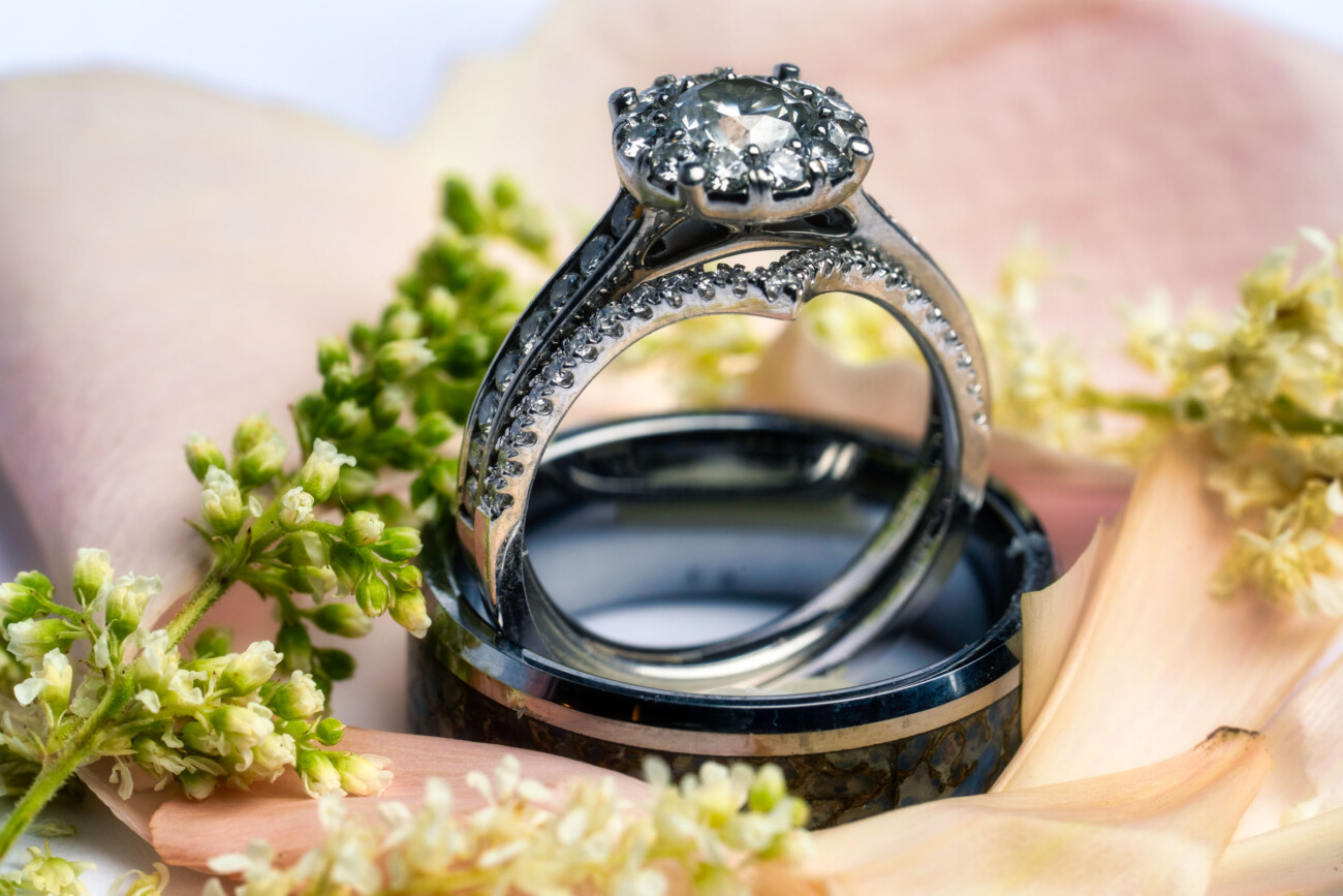A wedding engagement ring surrounded by flowers.