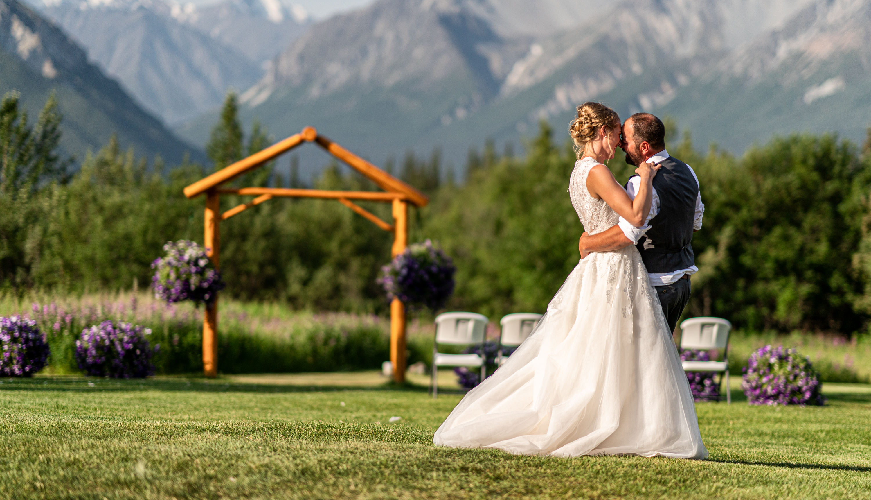 A newly married couple holds each other in a mountain garden during their Oregon wedding.